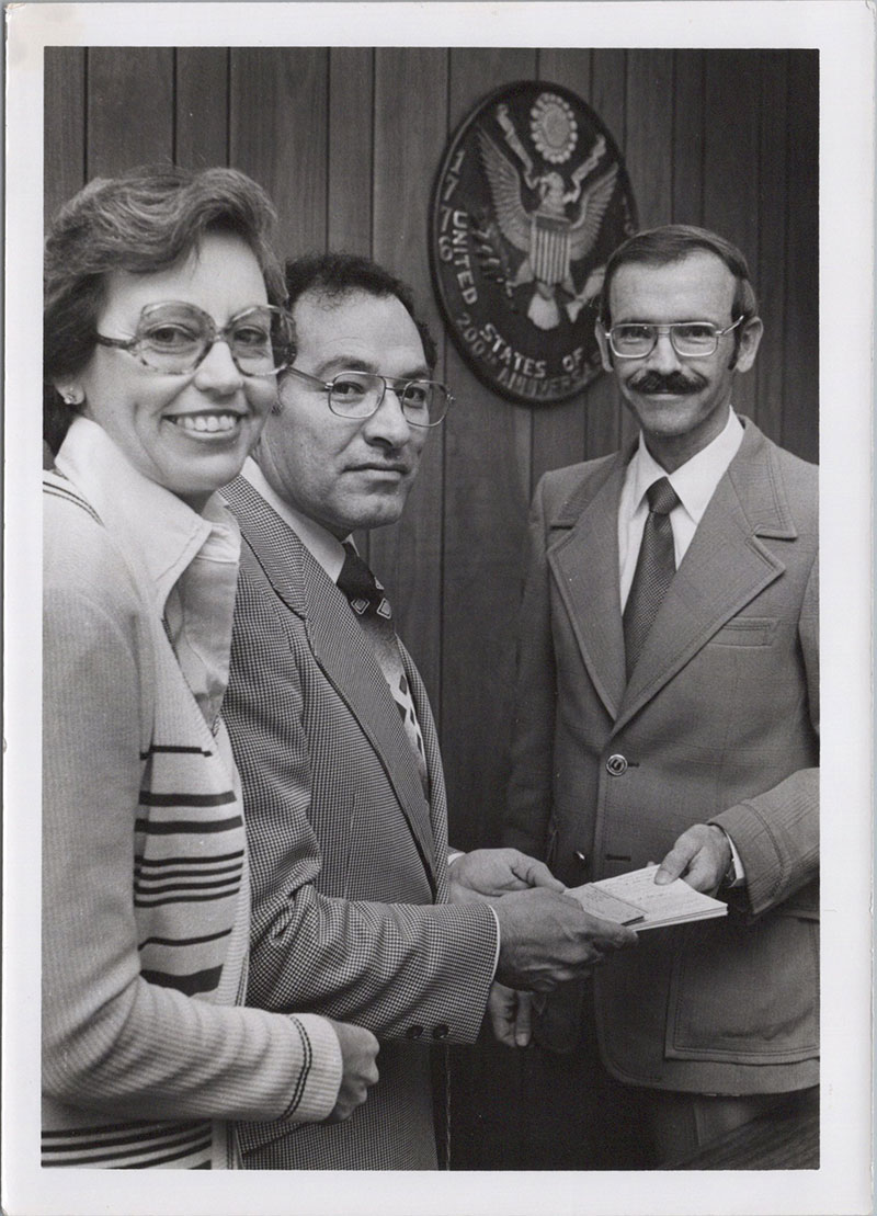 Dr. Billy F. Cowart is being handed his award for Man of the Year by two individuals. All three people are smiling at the camera.