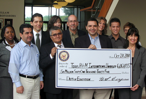 Congressman Henry Cuellar holding $6M check.