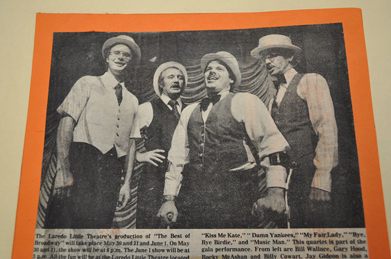 A quartet, in typical barber shop quartet fashion, is photographed singing.