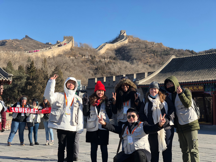 Melissa Olmeda taking a photo with locals in front of the Great Wall of China.