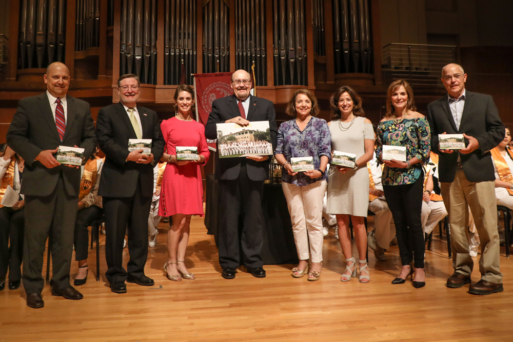 Paticipants of the event smile as they are on stage to receive the award.