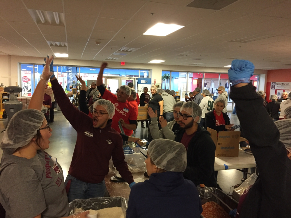 Students rallying up as they package meals during the annual TAMIU Make a Difference Day.