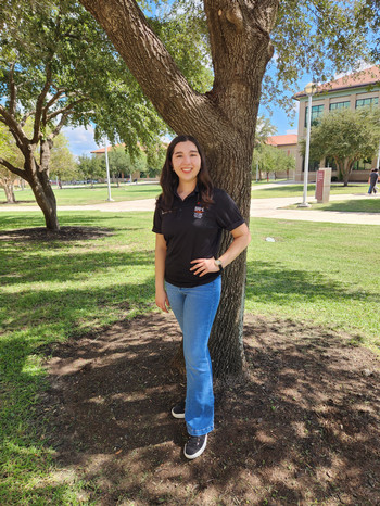 Student standing in front of a tree