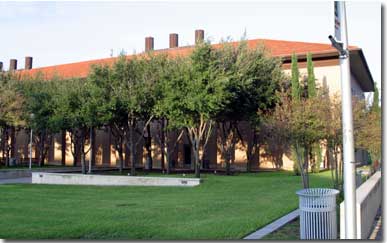 Picture of Cowart Hall with a view of the surrounding lawn and trees.