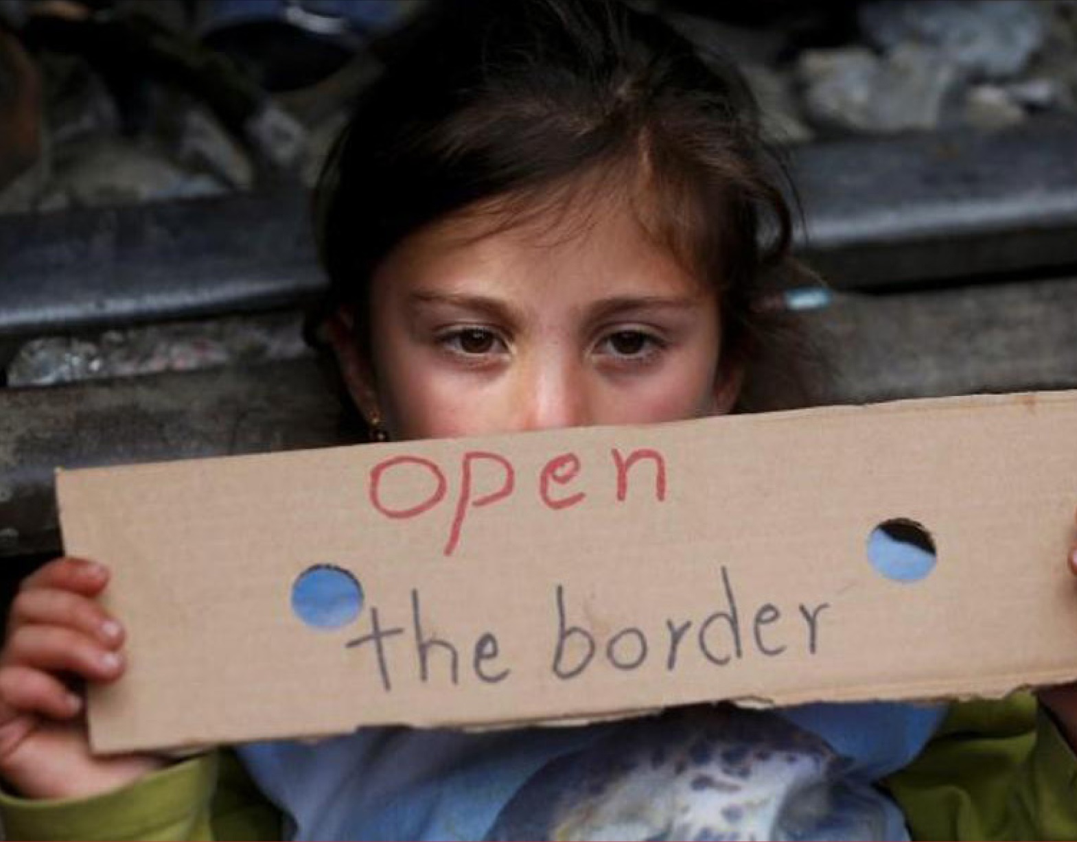 Child holding up a sign that reads "Open the Border"