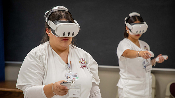 Two nursing students engaged in a virtual realtiy simulation.