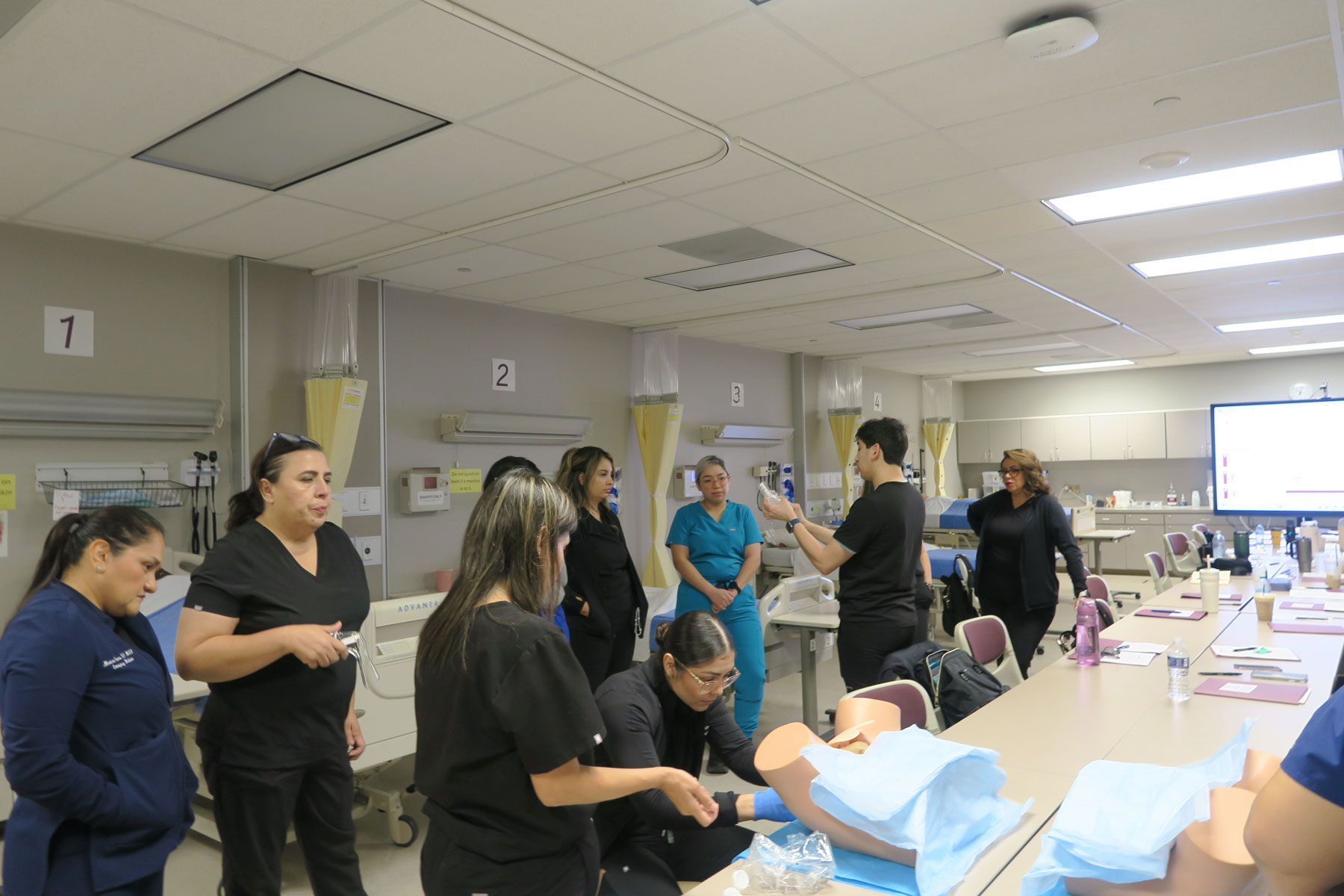 SANE Students working in a nursing lab with dummies
