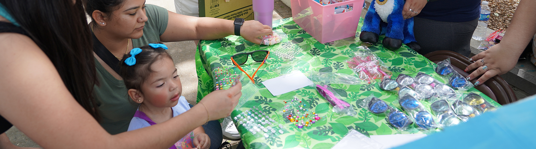 Discover TAMIU 2024 activity, students have children playing with stickers