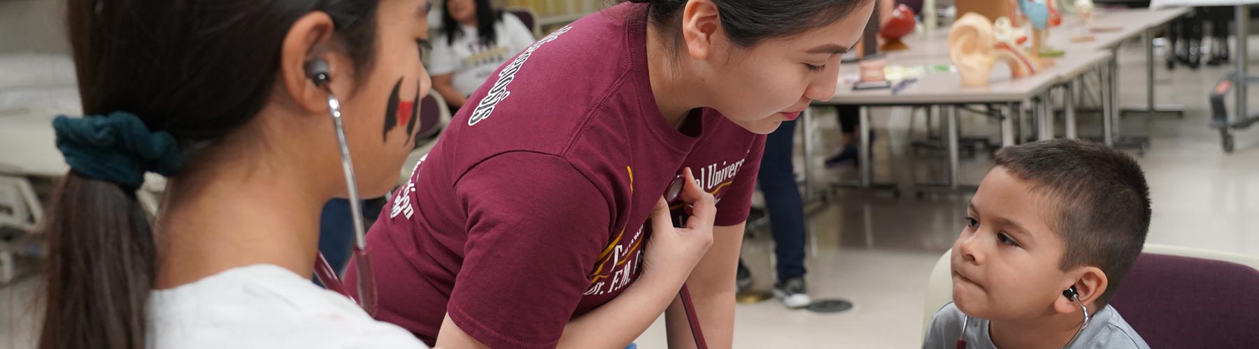 Discover TAMIU 2020 activity, where nursing students have children listen to their heartbeats with a stethoscope