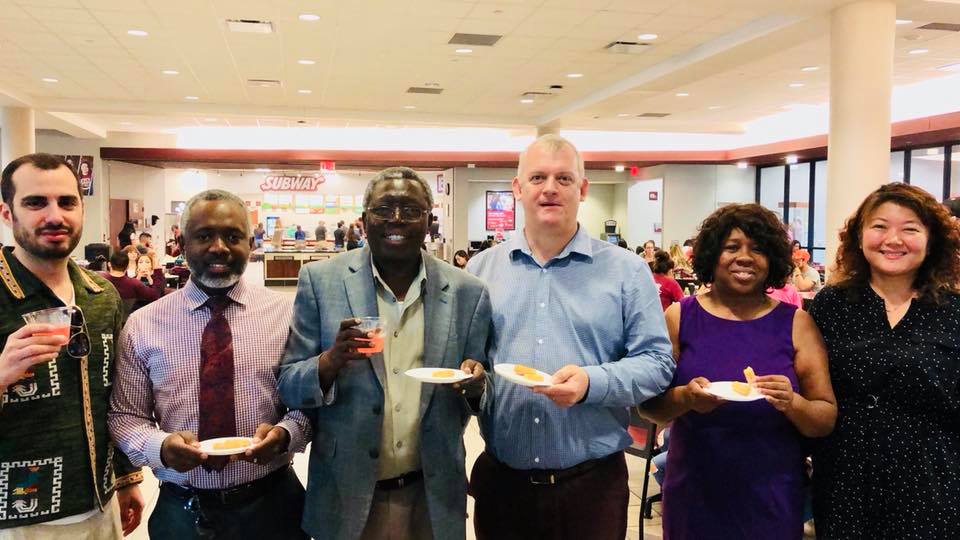 four gentlemen and a woman who are part of the TIDE committee enjoying food and punch