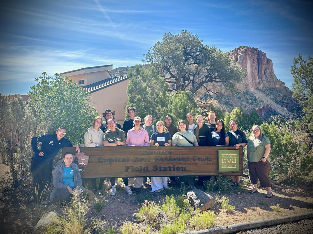 Honors student in front of capital reef welcome sign