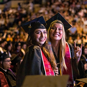 Graduates smile at the camera