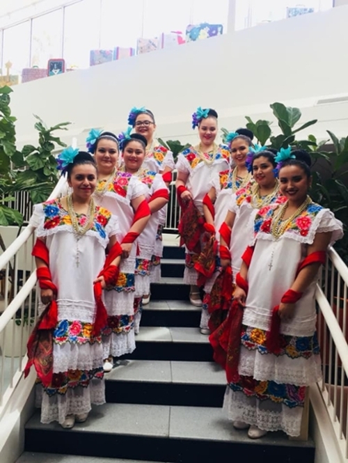 Folklorico dancers posing on a staircase.