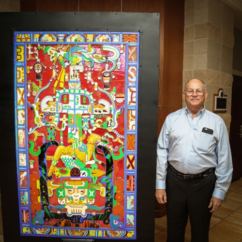 Artist Evan Quiros is pictured with his stunning Pakal Stained Glass Window, at home in the CFPA.