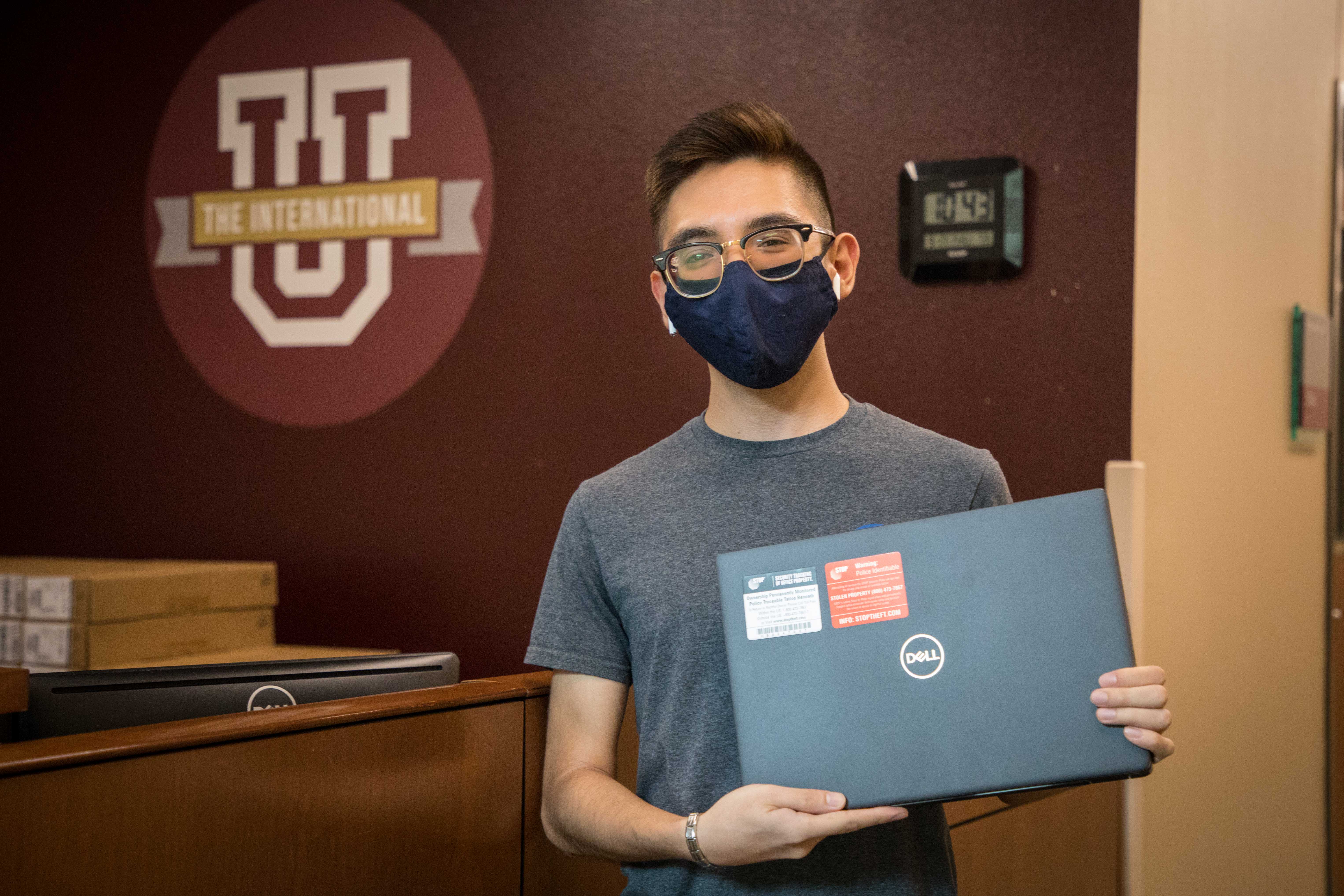 TAMIU student Alejandro Espinoza picks up his laptop for the Fall semester as part of the University's Loaner Laptop Program. 
