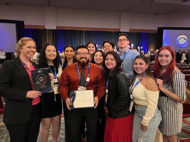 TAMIU faculty and students hold up an award at the ACS Meeting