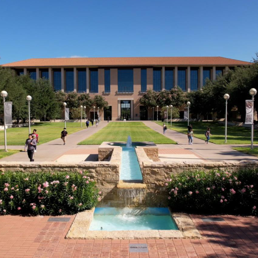 A group of students walking near the TAMIU Acequia Fountain