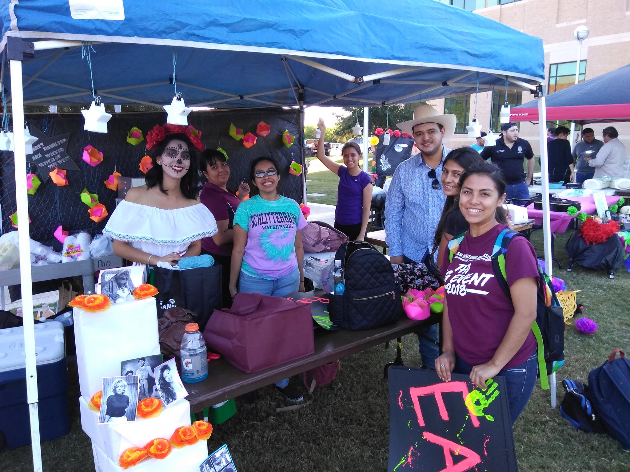 Students posing in front of halloween tent