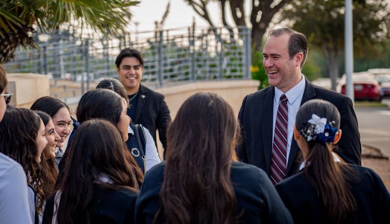 Dr. Maynard speaking with a group of students outdoors after Nuevo Laredo MOU signing
