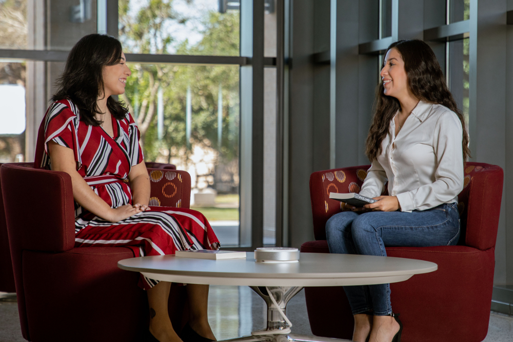 Two students sitting down talking 