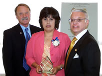 Roxanne Vedia accepting award from Dr. J. Michael Patrick and Mr. Tony Alvarez