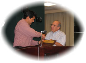 Orlando Navarro presents plaque to outgoing TAMIU Alumni President Henry Flores