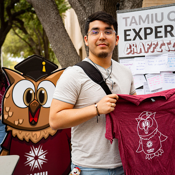 student holding a t-shirt